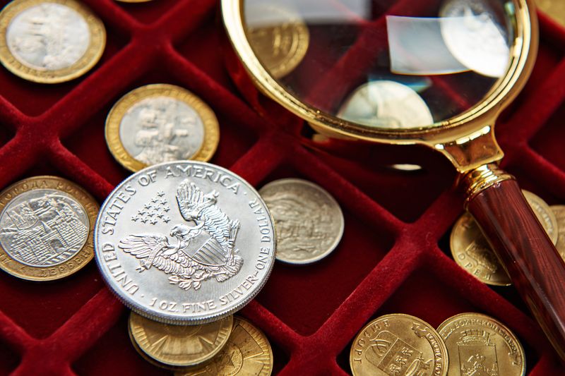 Silver Eagle and gold coins in a velvet tray with a magnifying glass at a Philadelphia coin evaluation