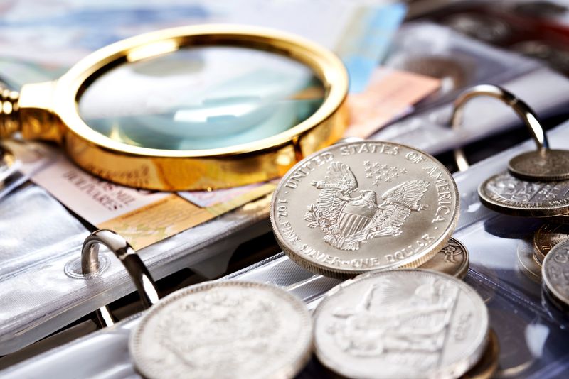 Silver Eagle, magnifier, coins and banknotes in a binder at a Philadelphia paper money evaluation